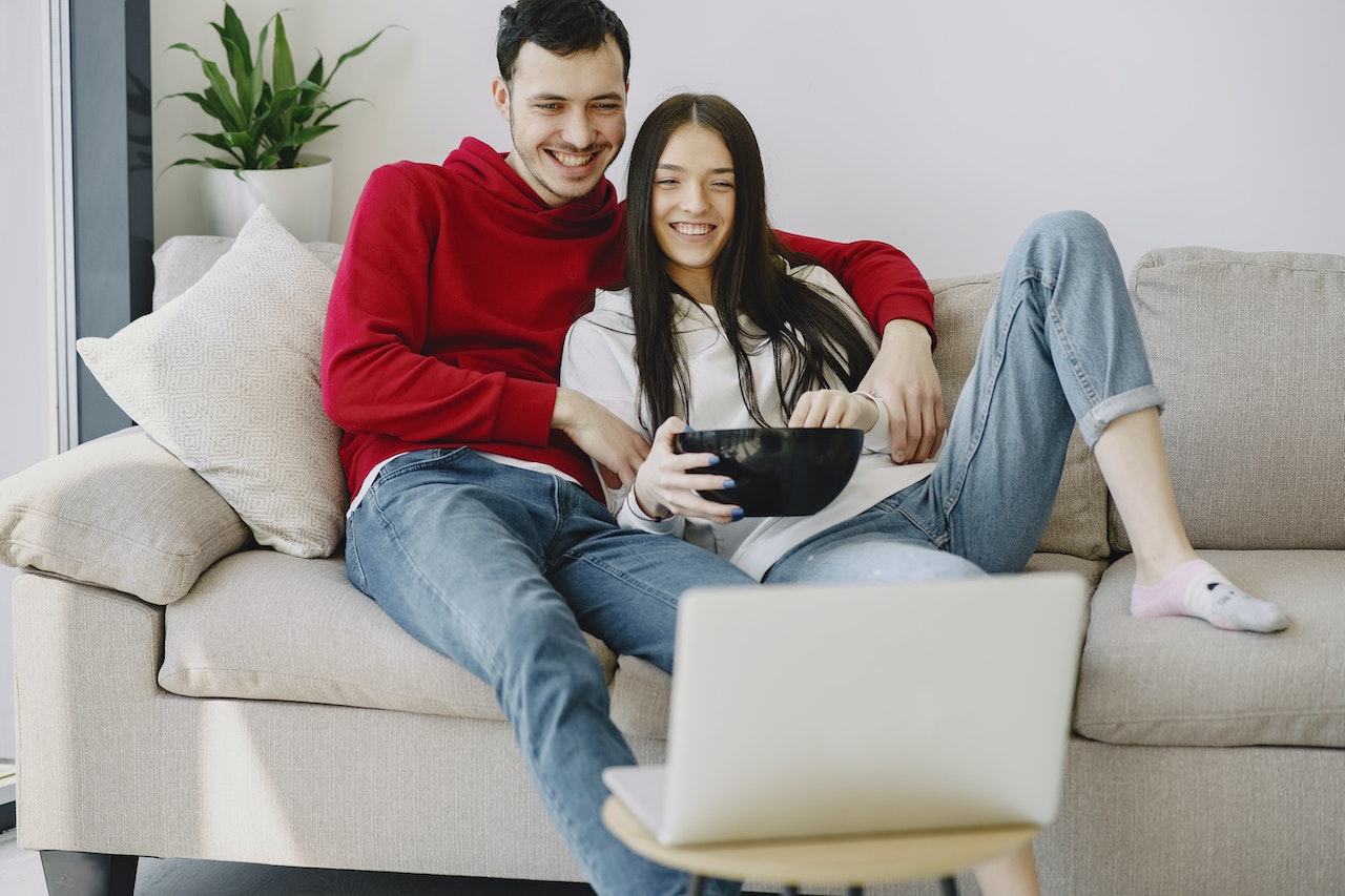 Happy couple watching movie on laptop in apartment | IFVOD TV