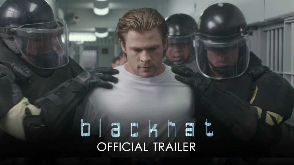 A man in a white shirt is escorted by two officers in riot gear down a corridor, hinting at high-stakes drama. The text over the image reads "blackhat OFFICIAL TRAILER," teasing one of the most intense Cyber Movies of the year. | IFVOD-TV.com